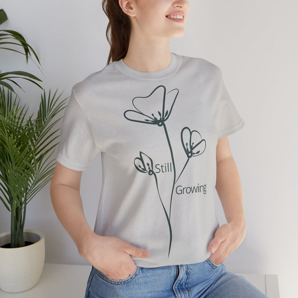 Still Growing Floral T-Shirt by Printify featuring minimalist floral design, casual fit, and inspirational message on soft fabric.