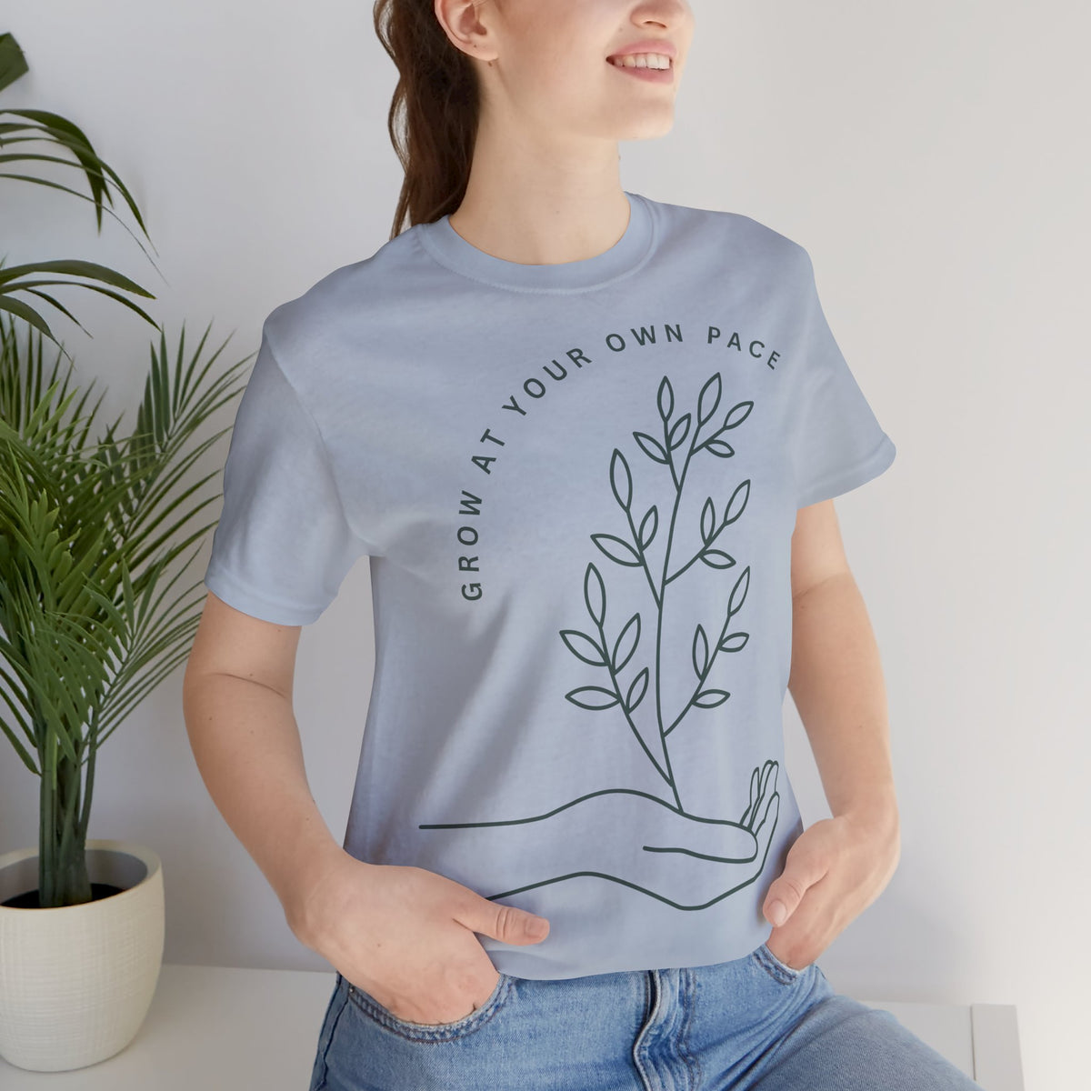 Minimal botanical T-shirt by Printify featuring "Grow At Your Own Pace" text on soft fabric, showcasing a nature-inspired design.