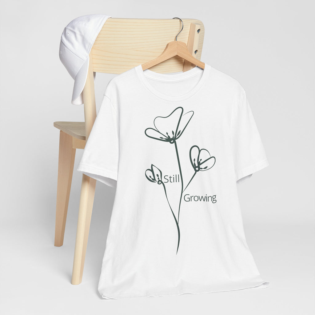Still Growing Floral T-Shirt by Printify, minimalist inspirational graphic tee featuring delicate floral design on soft fabric.
