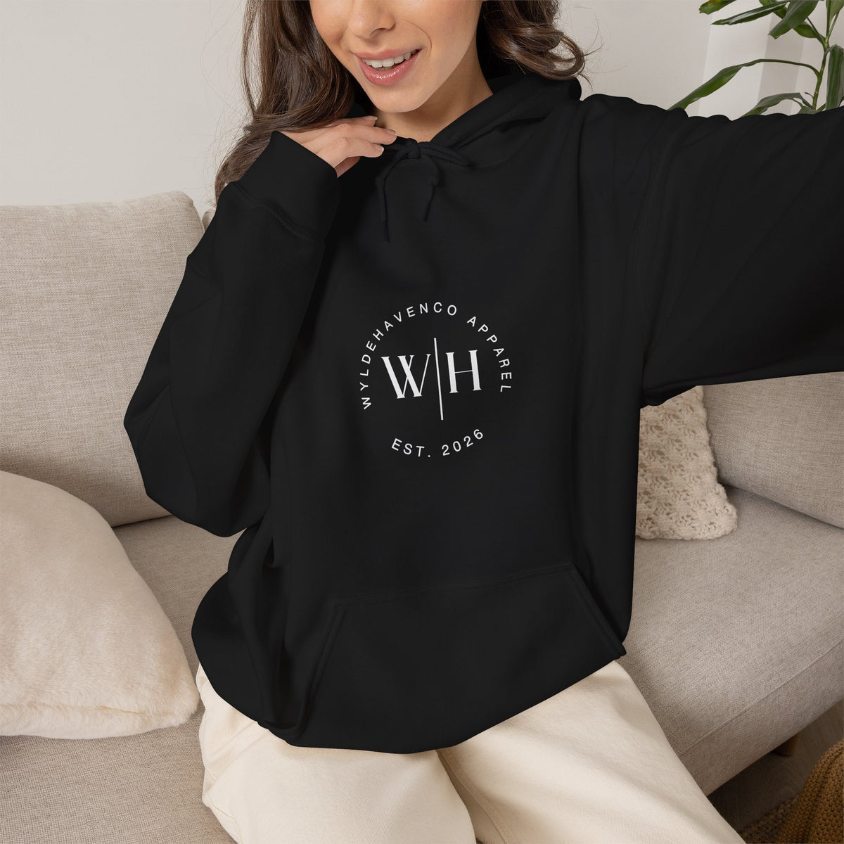 Black hoodie from WyldeHaven Apparel featuring a monogram circle logo and "Est. 2026" text on the front.