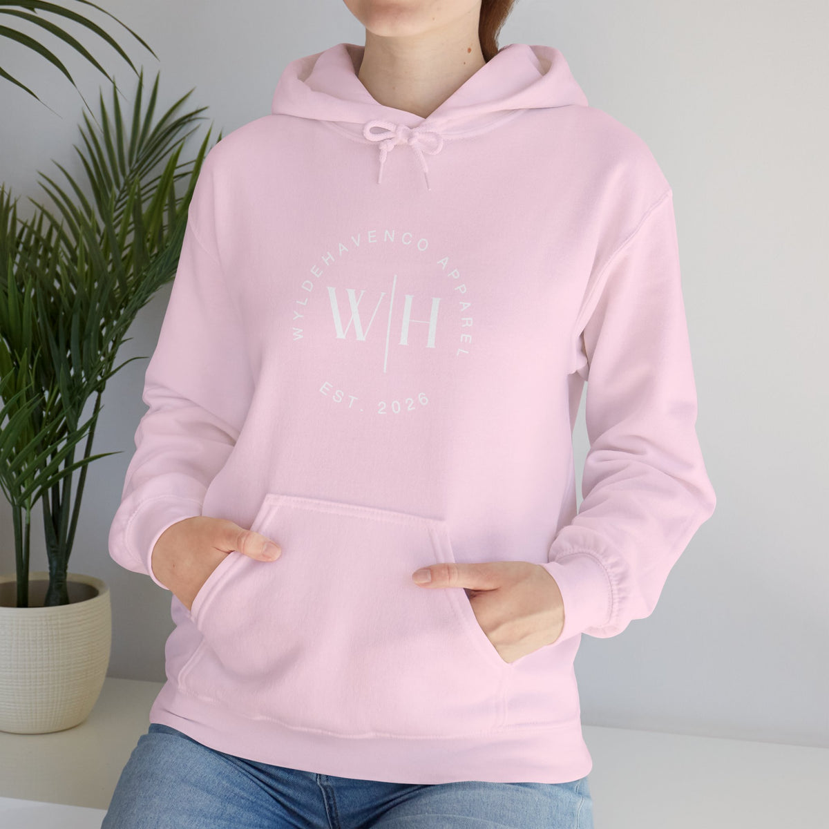 White hoodie featuring a Monogram Circle WyldeHaven Apparel Est. 2026 logo print on the front, casual sweatshirt for everyday wear.