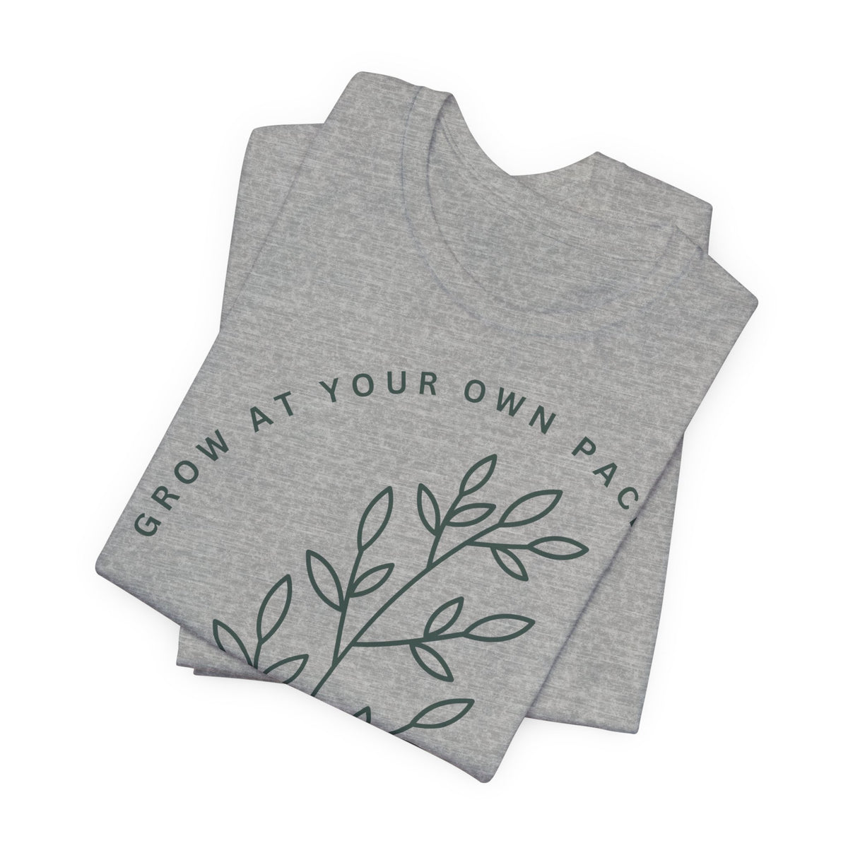 Minimal botanical design T-shirt with "Grow At Your Own Pace" slogan by Printify, featuring green plant illustrations on soft fabric.