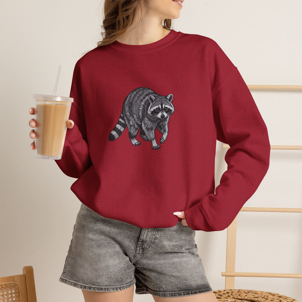 Raccoon graphic sweatshirt from Wyldelife Collection featuring wildlife art, with a detailed raccoon illustration on a cozy Printify sweatshirt.