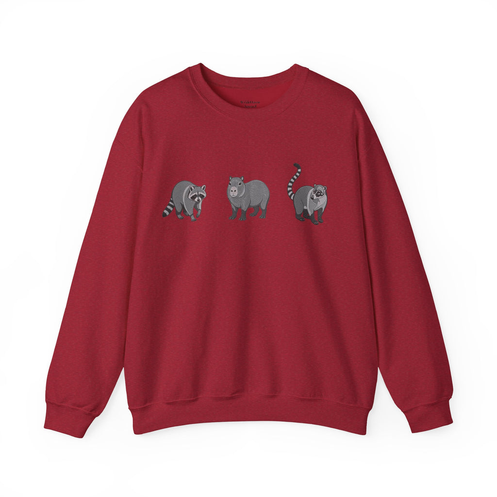 Wildlife Trio graphic sweatshirt featuring raccoon, capybara, and coati illustrations from Wyldelife Collection by Printify.
