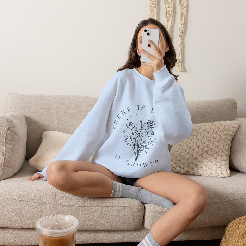 Light grey crewneck sweatshirt with floral minimalist design and the phrase "There Is Beauty in Growth" printed on the front.
