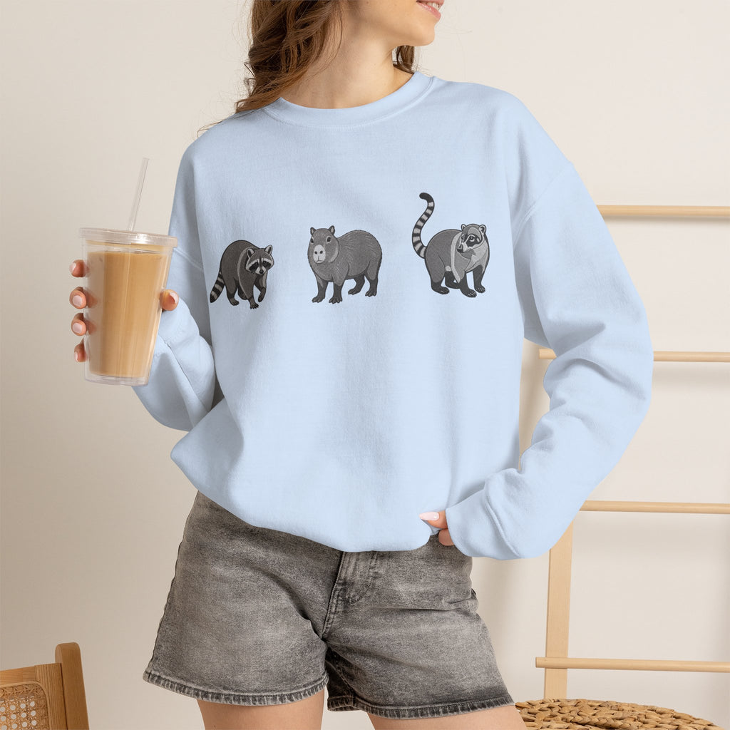 Wildlife Trio graphic sweatshirt featuring raccoon, capybara, and coati from Wyldelife Collection by Printify.