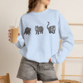 Wildlife Trio graphic sweatshirt featuring raccoon, capybara, and coati from Wyldelife Collection by Printify.