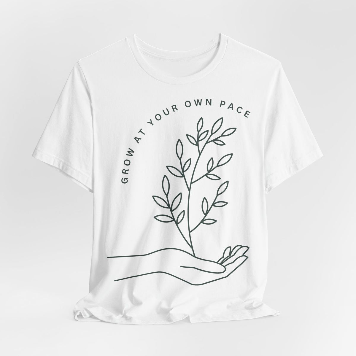 Minimal botanical print T-shirt with "Grow At Your Own Pace" slogan, featuring nature-inspired design on a casual Printify tee.