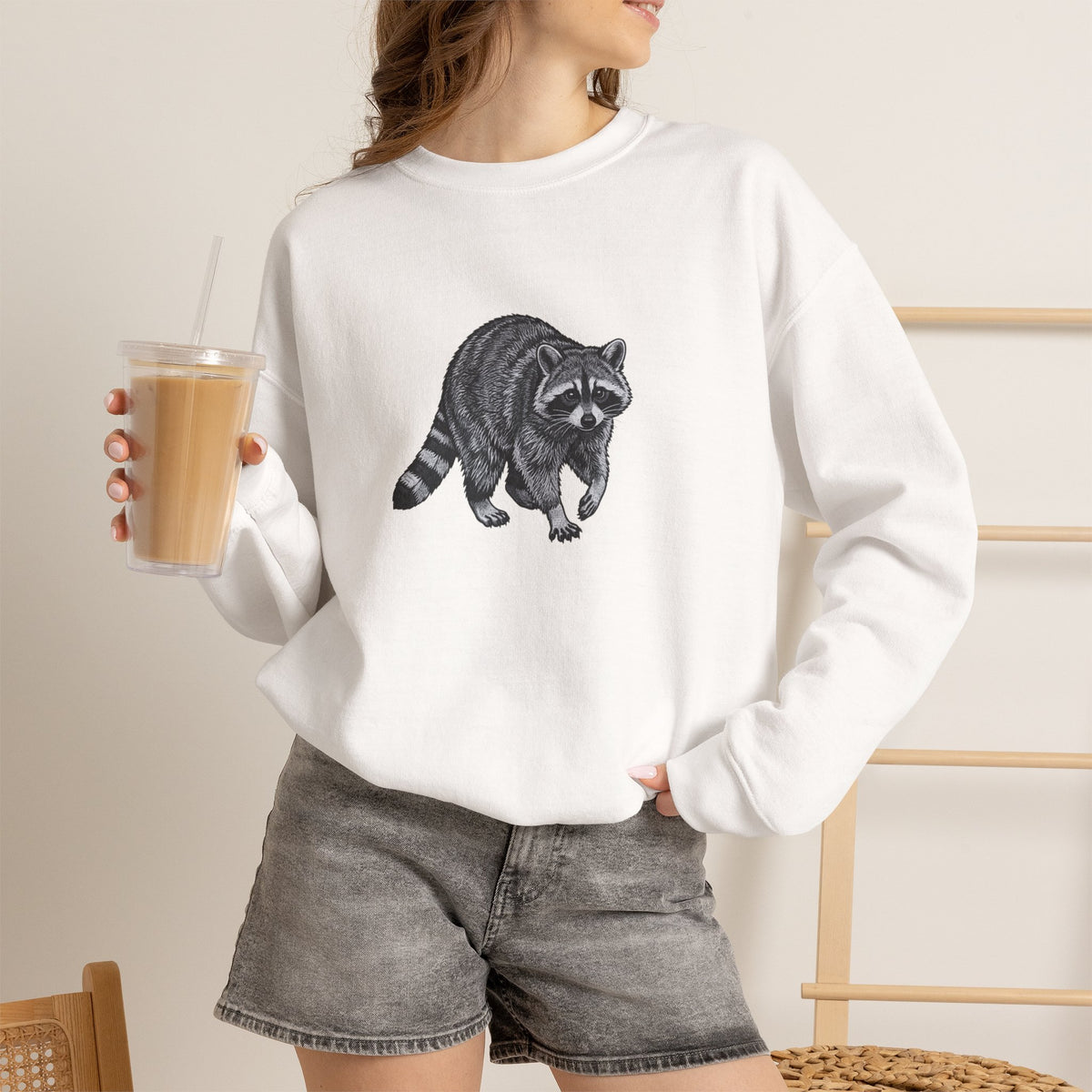 Raccoon graphic sweatshirt from Wyldelife Collection featuring wildlife art, made by Printify, showcasing a detailed raccoon illustration.