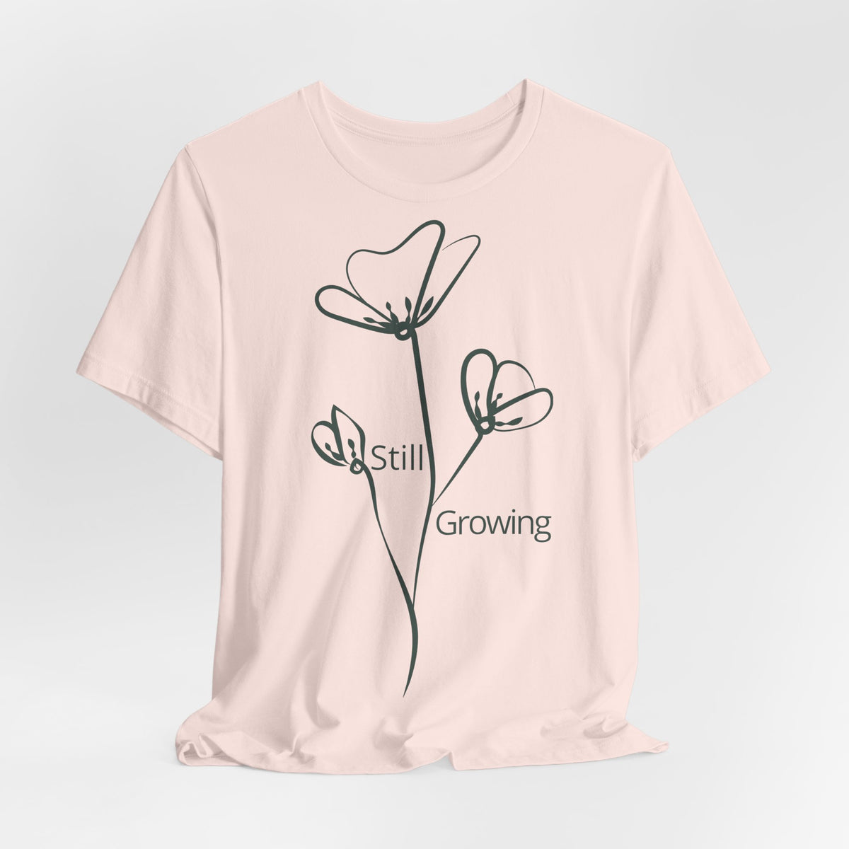 Still Growing Floral T-Shirt by Printify, minimalist inspirational tee featuring a delicate floral design on soft fabric.