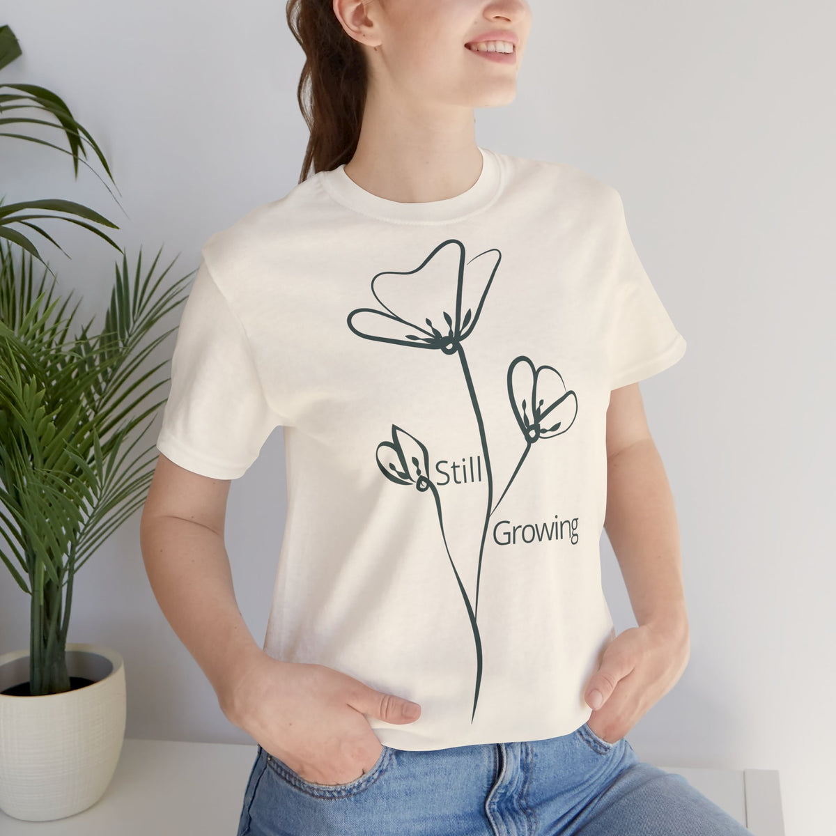 White Still Growing Floral T-shirt by Printify featuring minimalist floral design and inspirational message on soft cotton fabric.