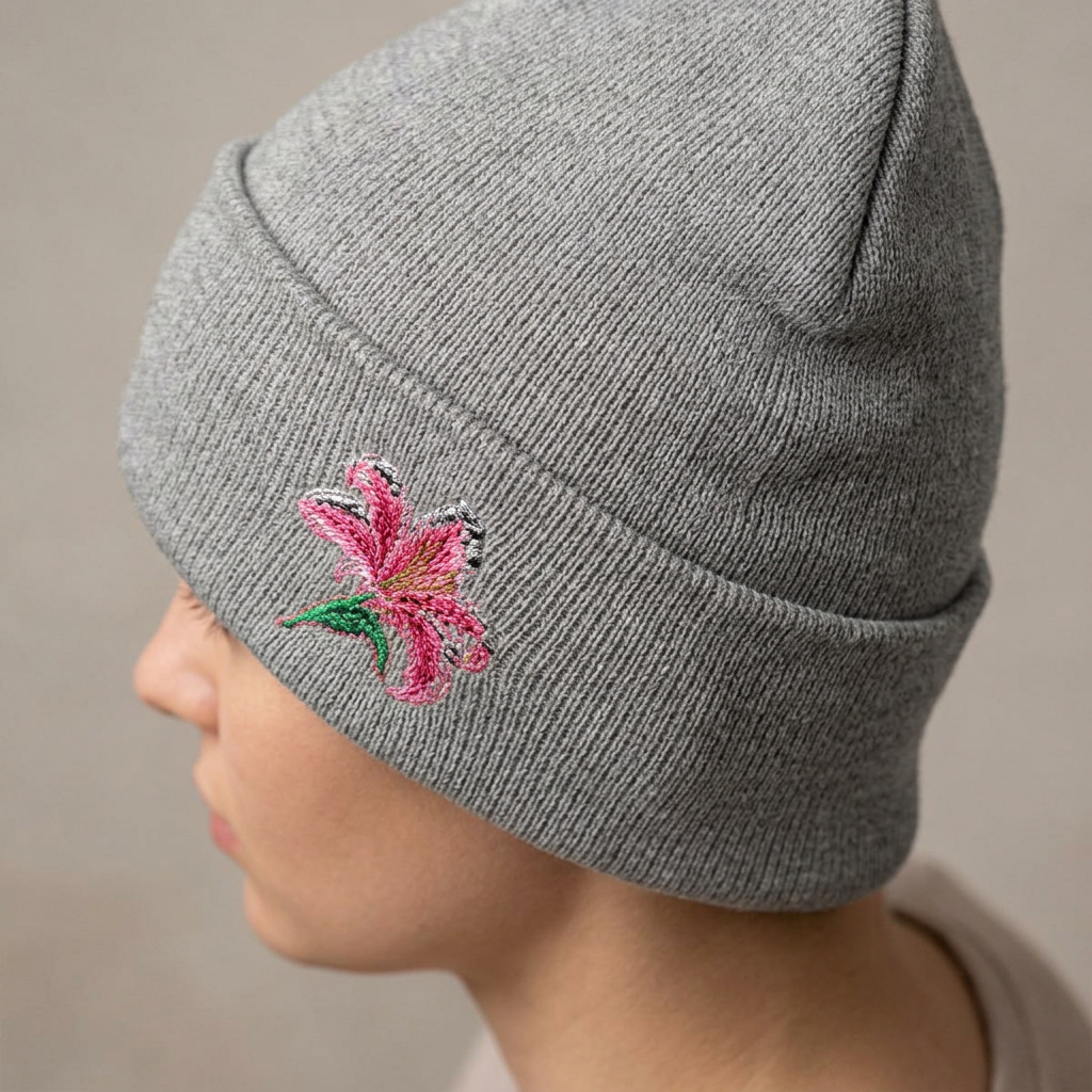 Pink Lily beanie hat with floral embroidery, soft knit, cuffed design, ideal for winter, from WyldeHaven Apparel by Printify.