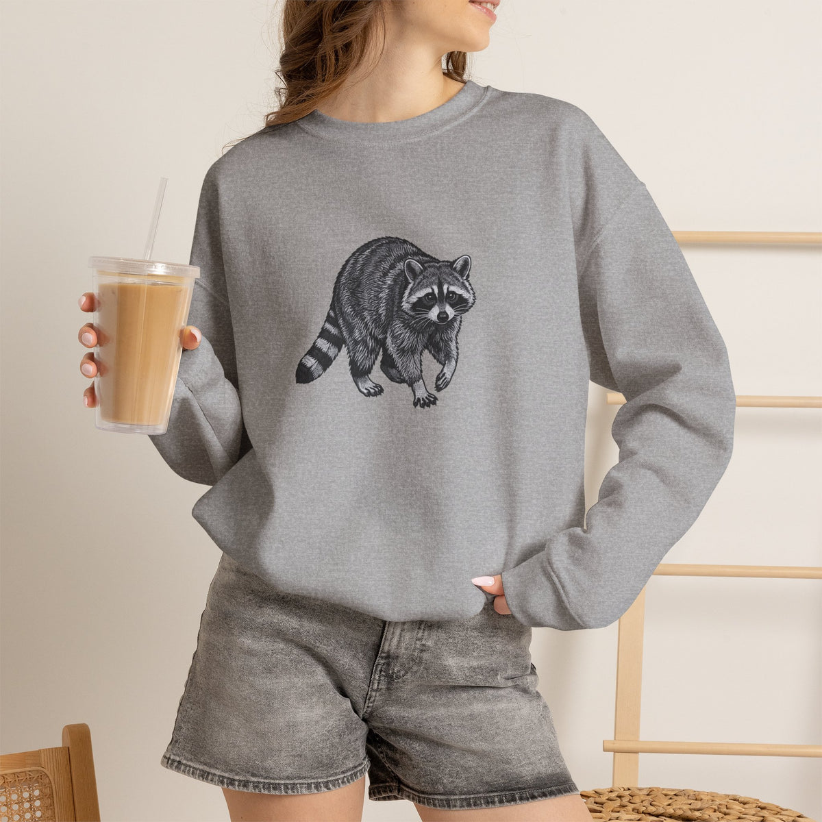 Raccoon graphic sweatshirt from Wyldelife Collection featuring wildlife art, with a detailed raccoon illustration on a cozy sweatshirt.