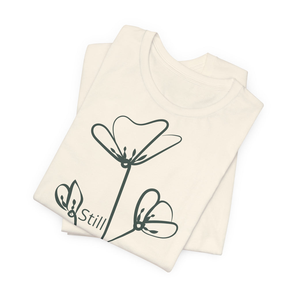 Still Growing floral print minimalist T-shirt by Printify, featuring a simple inspirational design on a casual cotton tee.
