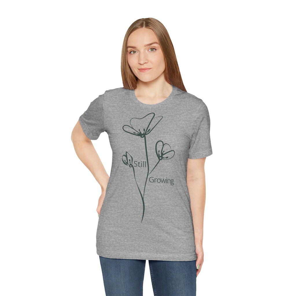 Still Growing Floral Tee by Printify, a minimalist inspirational T-shirt with a floral design, shown on a plain background.