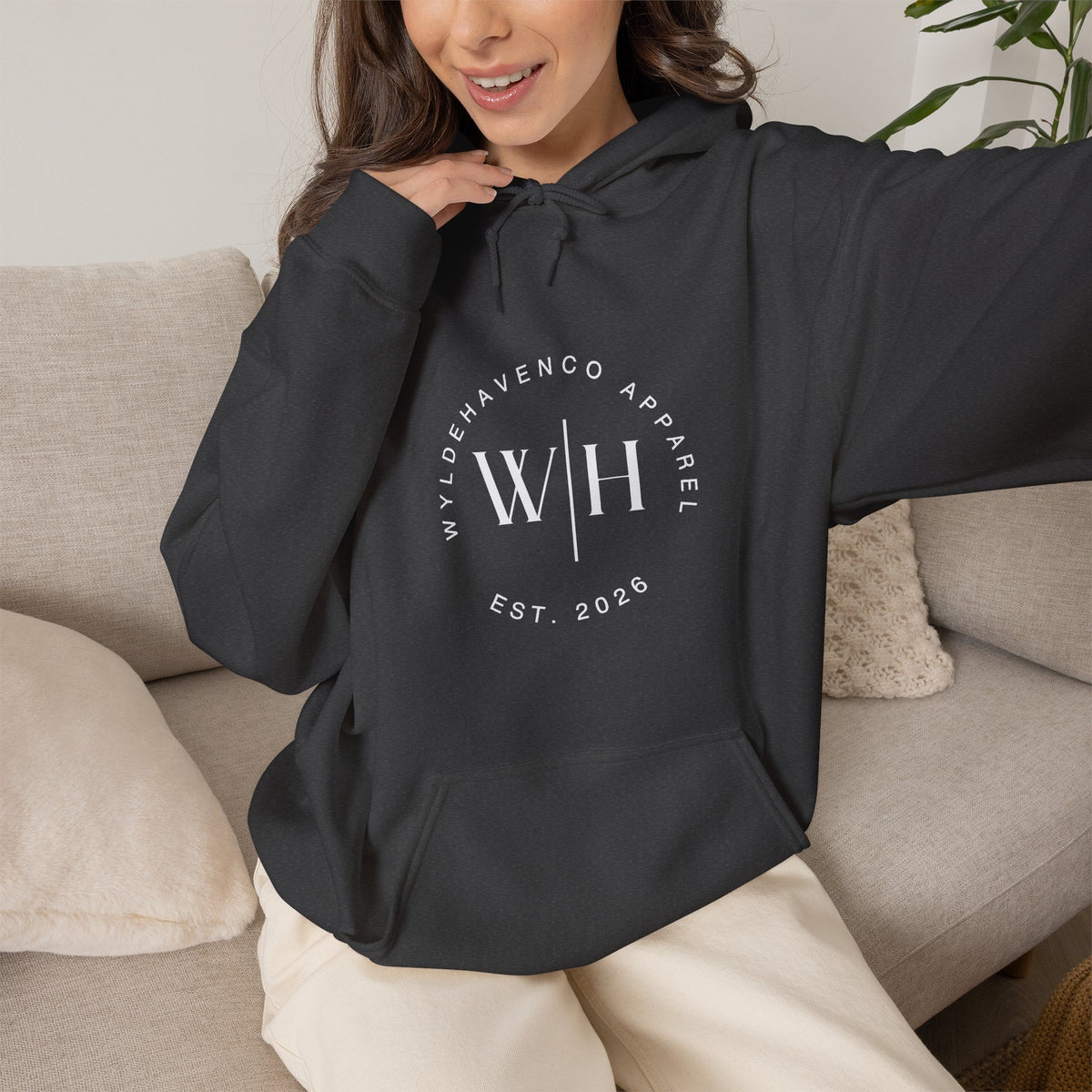 Black hoodie from WyldeHaven Apparel featuring a monogram circle logo and "Est. 2026" branding, with a comfortable sweatshirt fit.