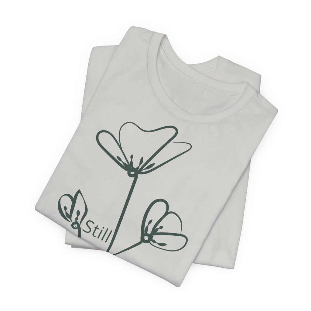 Still Growing floral T-shirt by Printify featuring minimalist inspirational design, casual fit, and vibrant floral artwork.