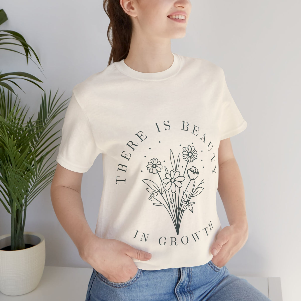 Printify floral T-shirt featuring "There Is Beauty In Growth" design, with vibrant flower illustrations on a casual tee.