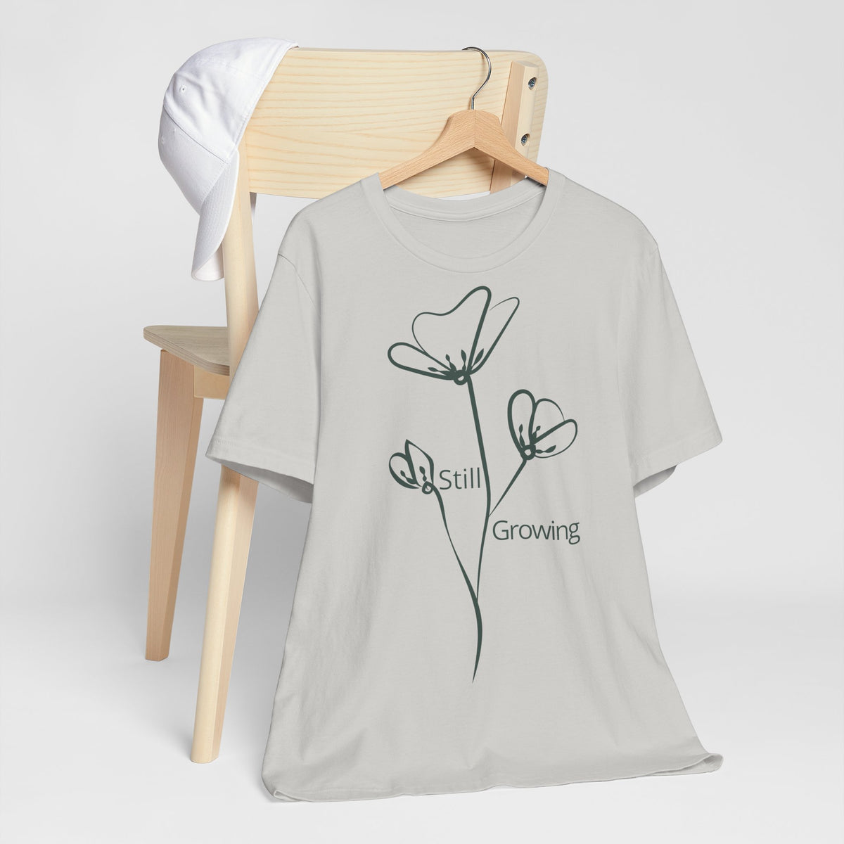 Still Growing Floral T-Shirt by Printify, minimalist inspirational graphic tee featuring colorful floral design on soft fabric.