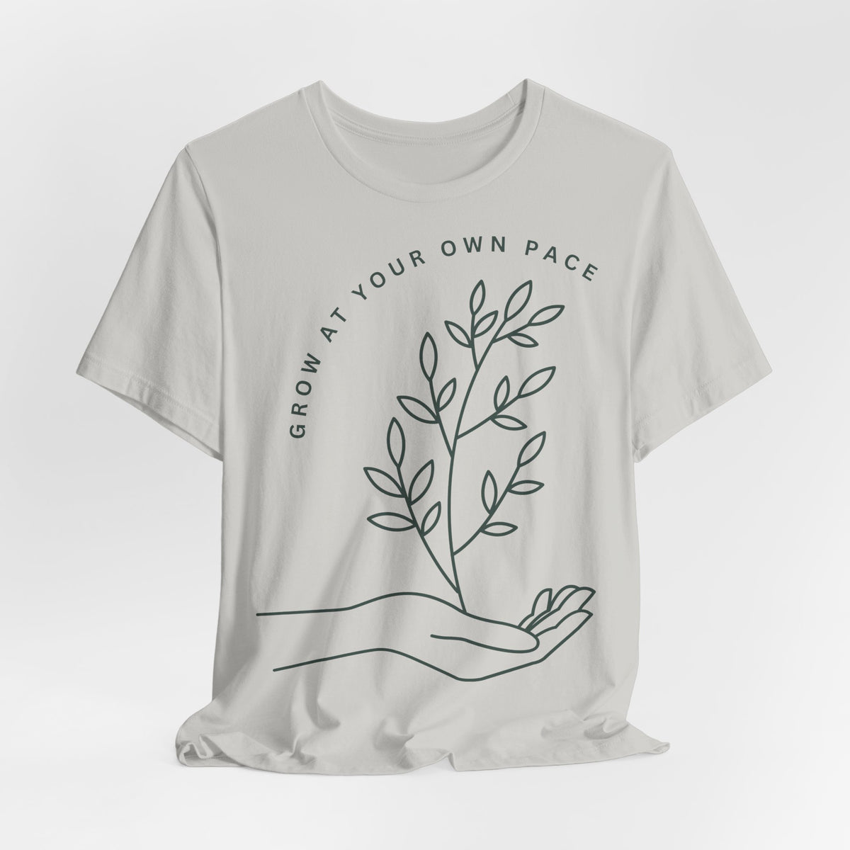 Minimal botanical Printify T-shirt featuring "Grow At Your Own Pace" slogan on soft, casual fabric.