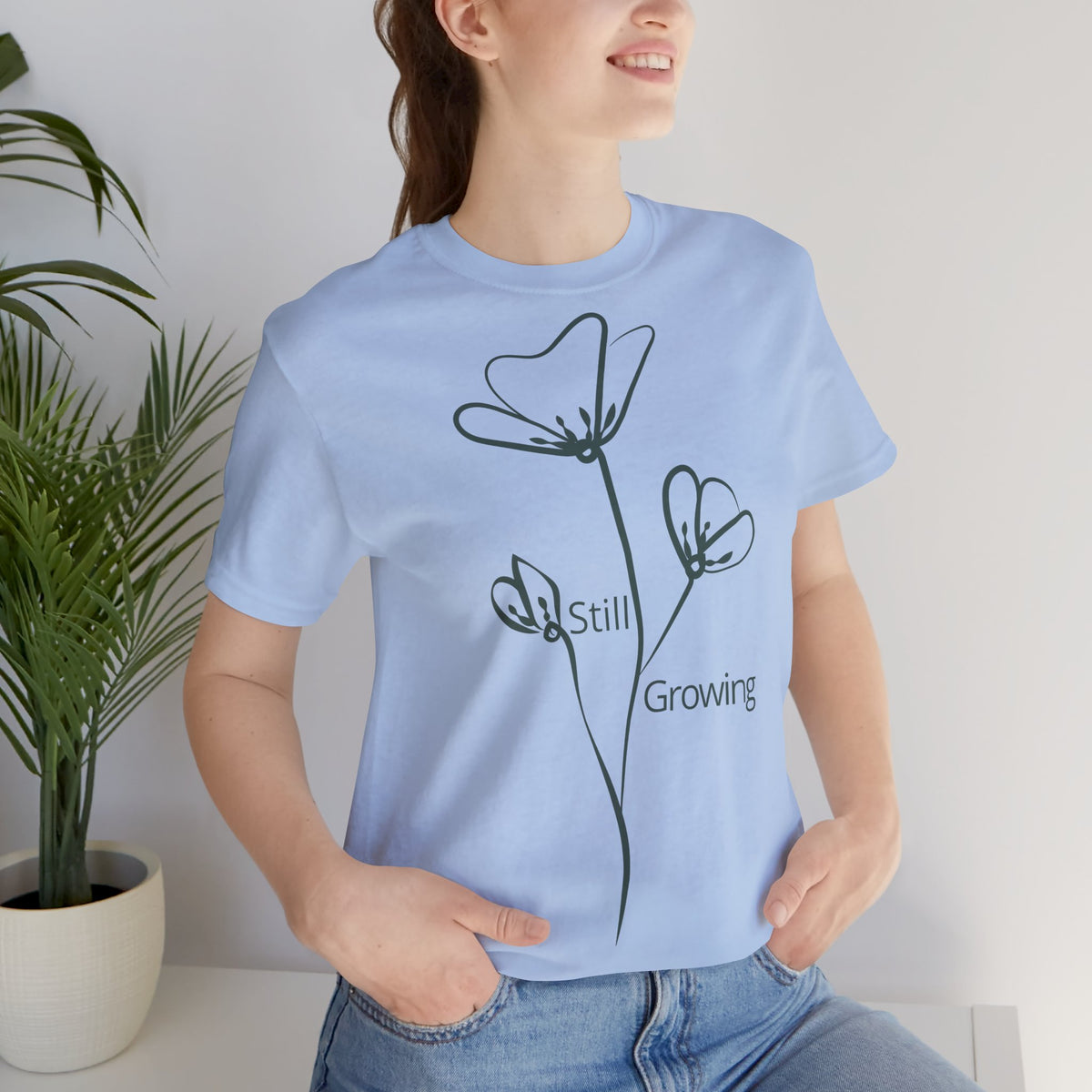 Still Growing floral print minimalist T-shirt by Printify featuring a simple, inspirational floral design on a casual tee.