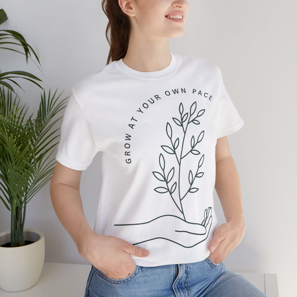 Minimal botanical print T-shirt with "Grow At Your Own Pace" slogan, by Printify, featuring a simple plant design on soft fabric.