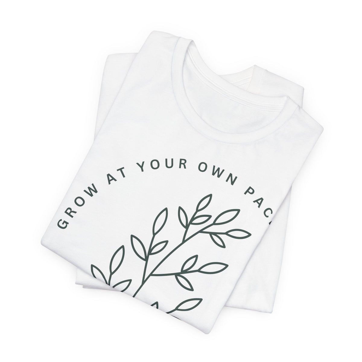 Minimal botanical print T-shirt from Printify with "Grow At Your Own Pace" slogan, featuring green plant illustrations on soft fabric.