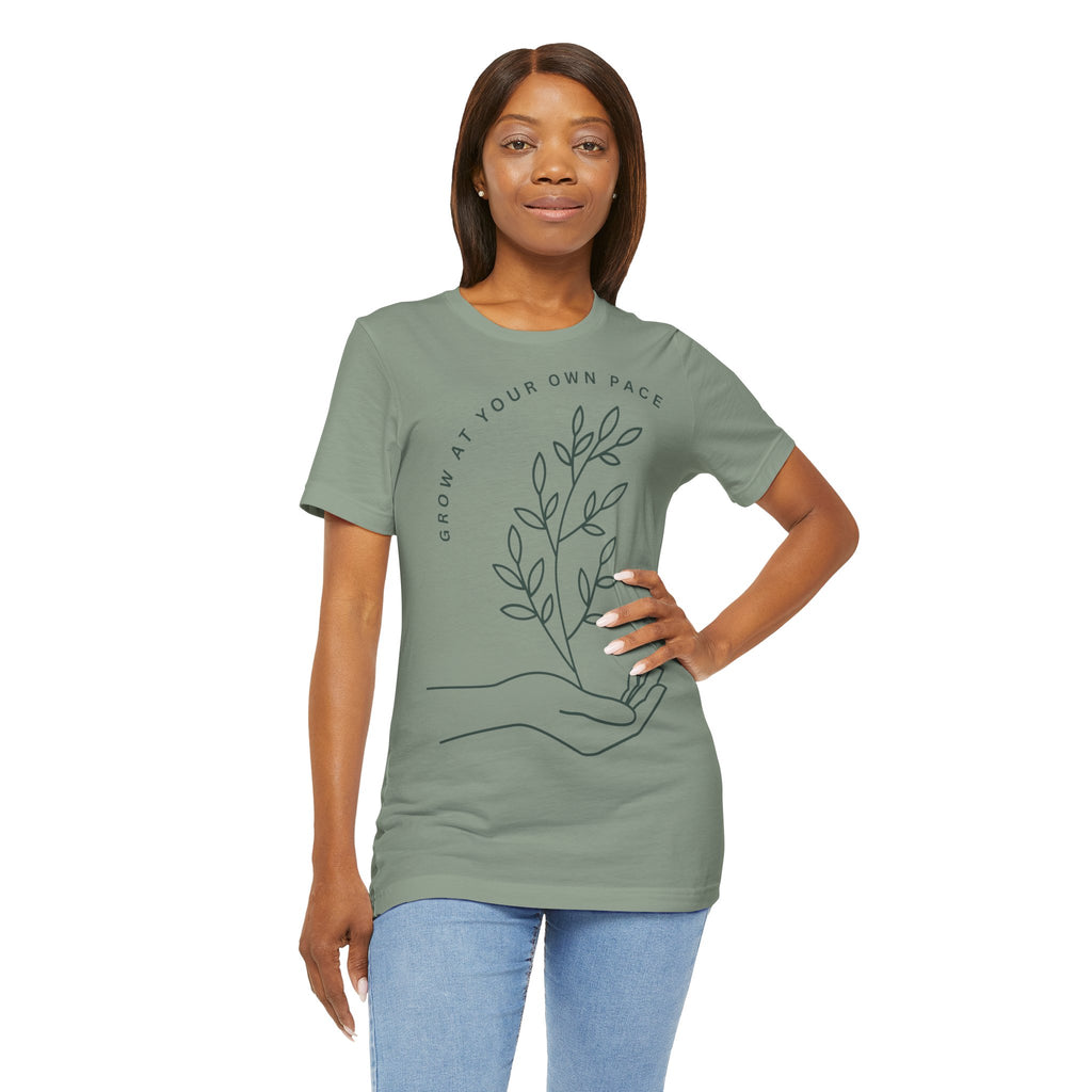 Minimal botanical print T-shirt from Printify featuring "Grow At Your Own Pace" slogan, casual unisex tee in soft fabric.