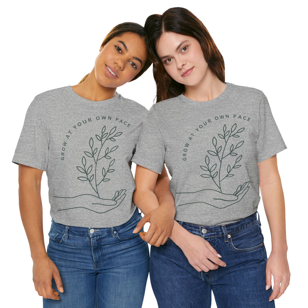 Minimal botanical t-shirt by Printify featuring "Grow At Your Own Pace" slogan on soft fabric with leafy plant illustrations.