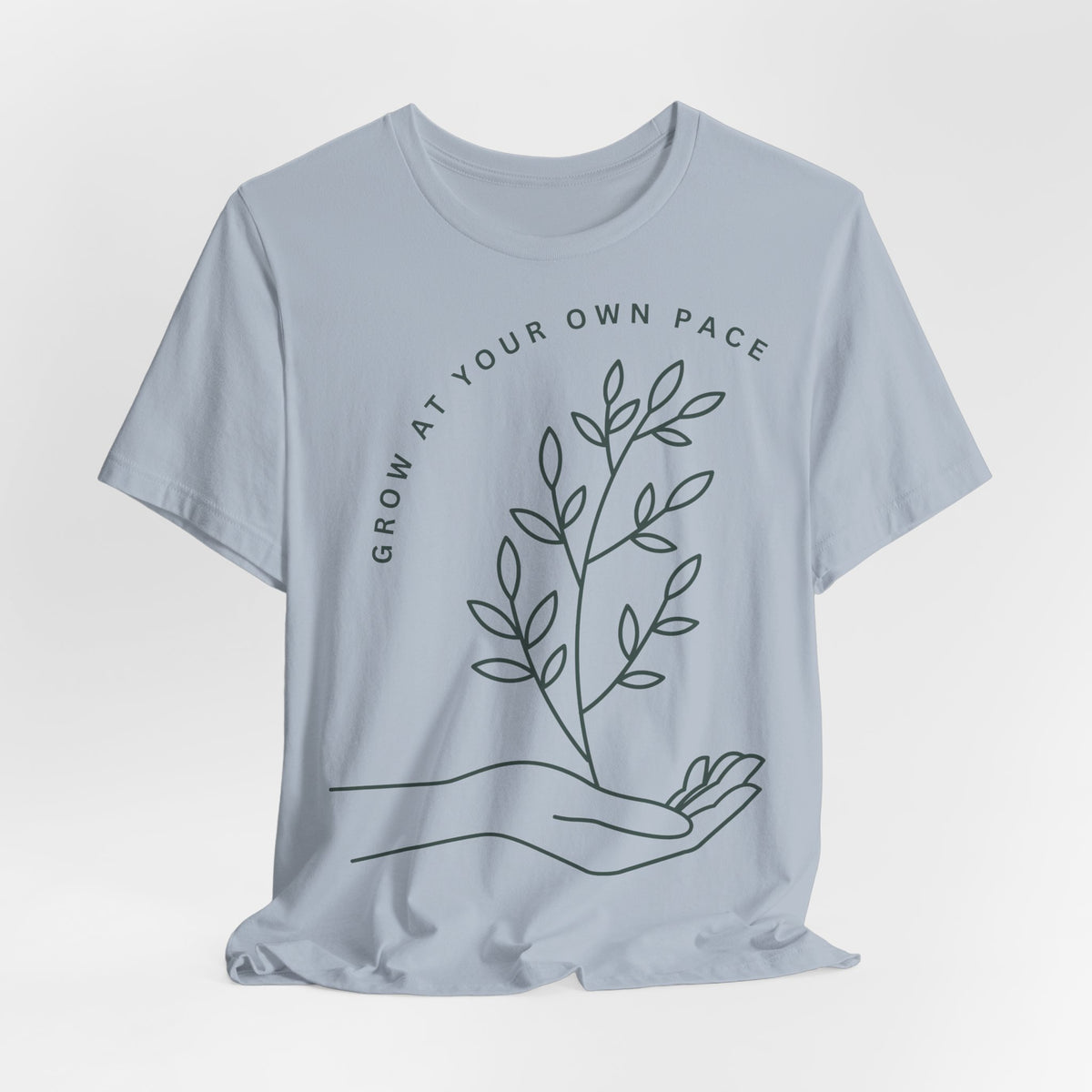 Minimal botanical t-shirt by Printify featuring "Grow At Your Own Pace" slogan on a soft fabric tee.