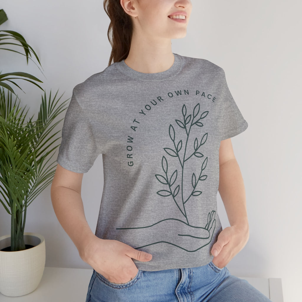 Minimal botanical print T-shirt by Printify featuring "Grow At Your Own Pace" slogan on a casual cotton tee.